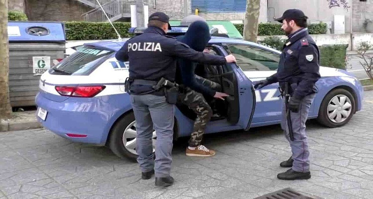 عناصر شرطة إيطالية أثناء مرافقة مواطن أجنبي
